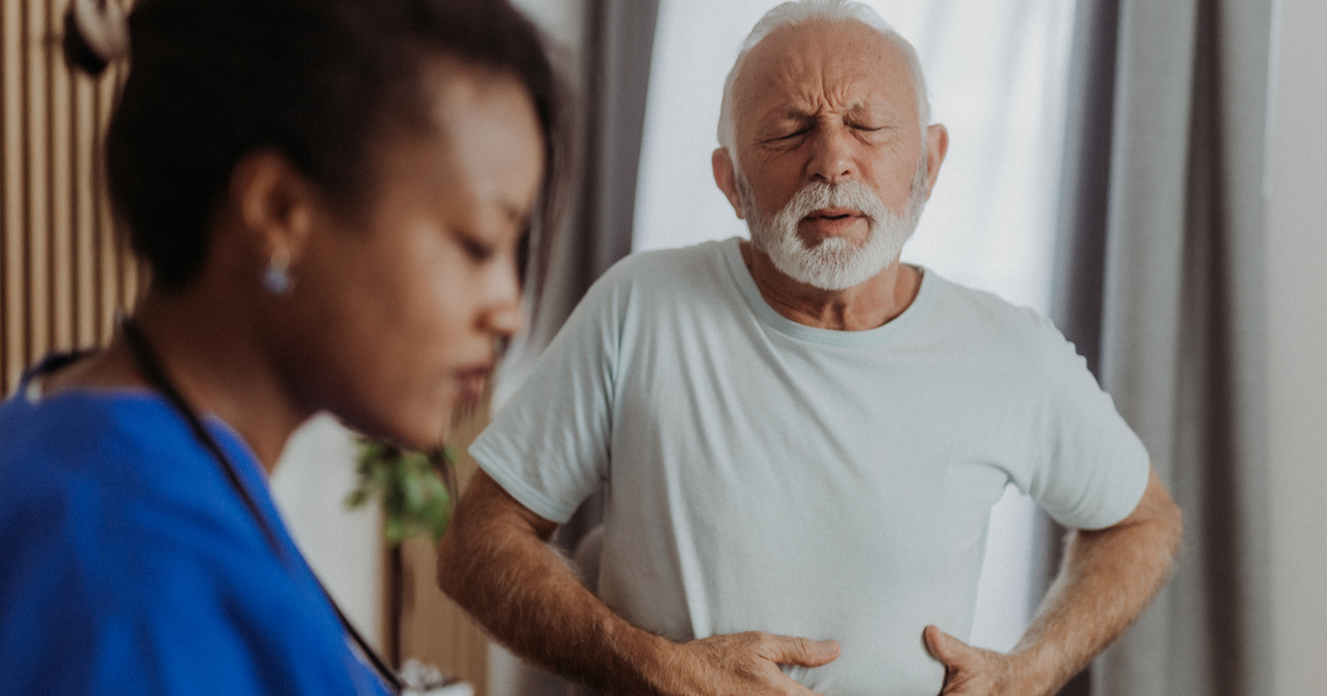 Nurse with an elderly man with stomach pain.